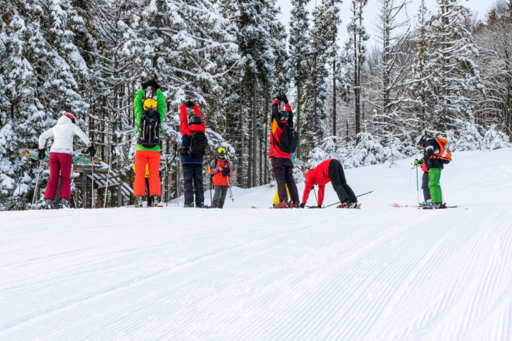 Aufwärmübungen zum Start eines Skitages helfen dabei, Verletzungen zu vermeiden. Aufwärmübungen zum Start eines Skitages helfen dabei, Verletzungen zu vermeiden.