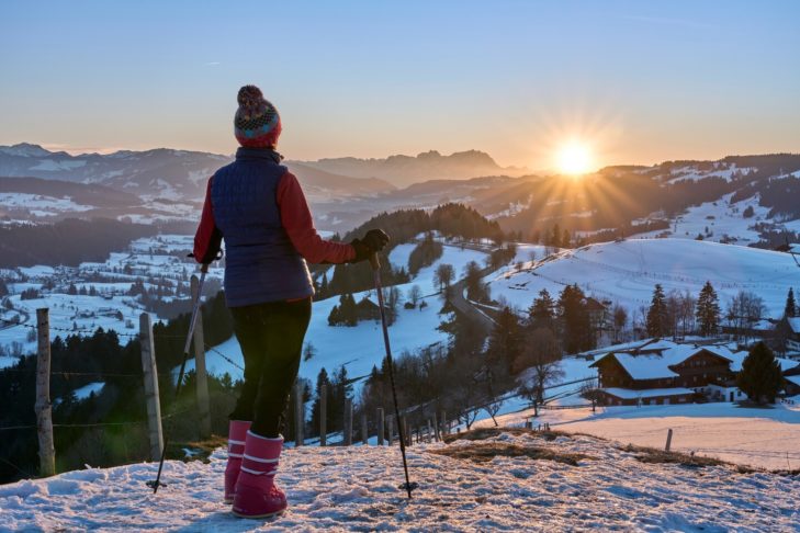 Winterwandern bei Sonnenuntergang im Vorarlberger Wald.